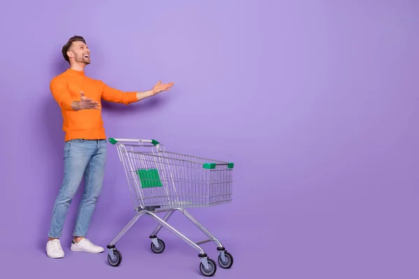 Full body photo of overjoyed dobrá nálada muž jít nakupovat úlovek velké prodejní kupóny izolované na fialové barvy pozadí — Stock fotografie