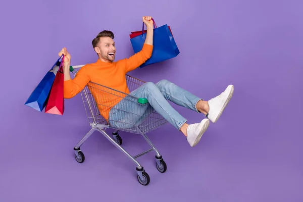 Full body photo of attractive overjoyed man excited to see huge bargains on black friday isolated on violet color background — стоковое фото