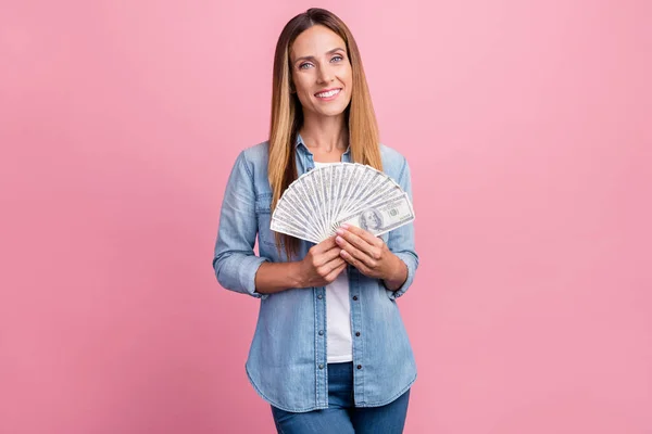 Foto di giovane allegra signora tenere dollari banconote risparmio di reddito isolato su sfondo di colore rosa — Foto Stock