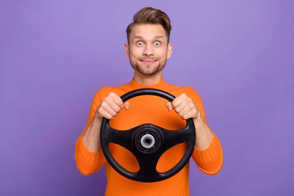 Foto van onder de indruk funky kerel gekleed oranje pullover schrikken rijden auto geïsoleerde paarse kleur achtergrond — Stockfoto