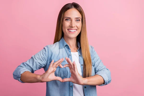 Foto av ung glad dam visa fingrar hjärta figur hjärta känslor isolerad över rosa färg bakgrund — Stockfoto
