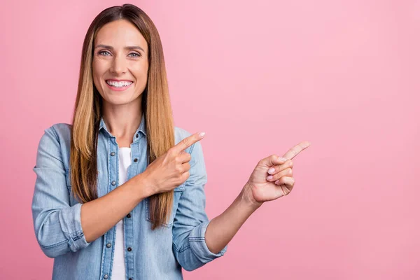 Foto av ung glad kvinna visar fingrarna tomt utrymme rekommenderar föreslår banner isolerad över rosa färg bakgrund — Stockfoto