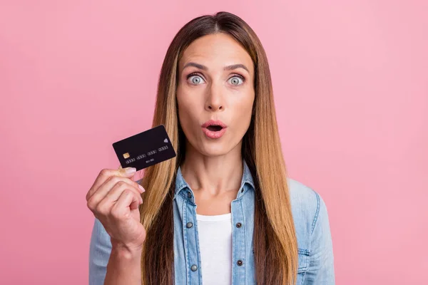 Fénykép a fiatal lenyűgözött nő tartsa bankkártya nyereség haszon elszigetelt felett rózsaszín színű háttér — Stock Fotó