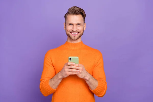 Photo of good mood positive man chatting with girlfriend in cellphone gadget isolated on purple color background — ストック写真