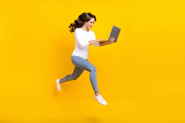 Foto de mulher bonita usar camisa branca conversando moderno gadget jumping correndo isolado cor amarela fundo — Fotografia de Stock