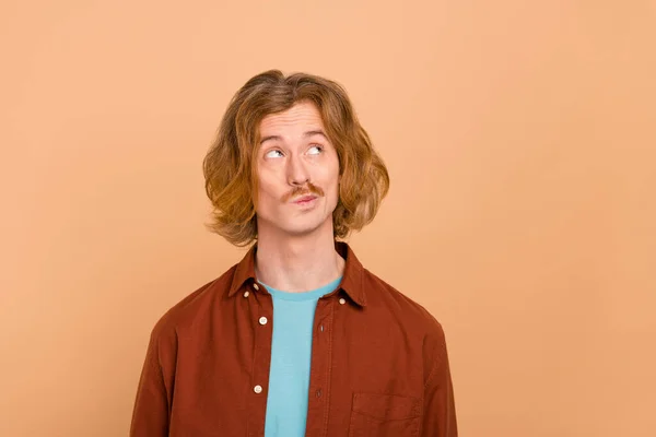 Porträtt av attraktiva funky förvirrad rödhårig kille overthinking lösning isolerad över beige pastell färg bakgrund — Stockfoto