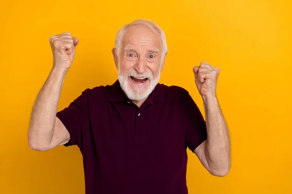 Foto de hooray anciano hombre puño gritar desgaste oscuro camiseta aislada sobre fondo de color amarillo — Foto de Stock