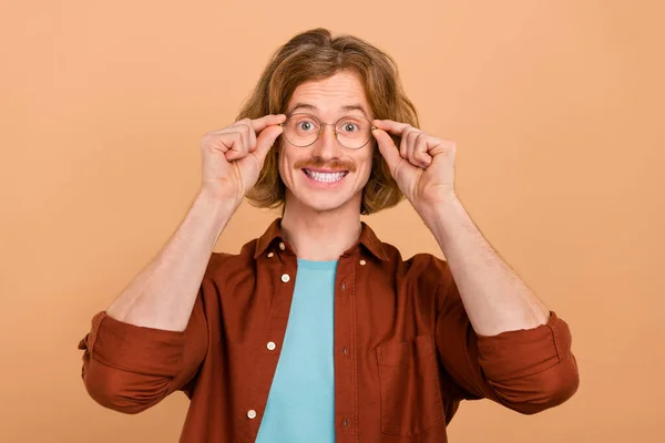 Portret van aantrekkelijke vrolijke intellectuele roodharige man aanraken specs geïsoleerd over beige pastel kleur achtergrond — Stockfoto