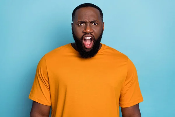 Фото озлобленного шокированного парня носить оранжевую футболку крича вы открываете рот изолированный синий цвет фона — стоковое фото