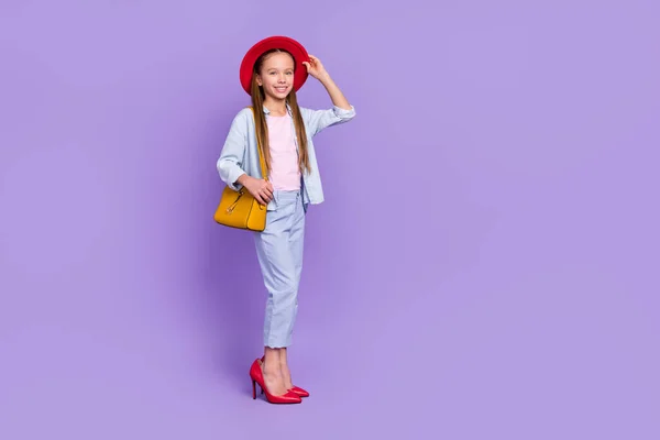 Fénykép a fényes imádnivaló kis iskolás lány visel farmer ing séta anya cipő üres tér elszigetelt lila szín háttér — Stock Fotó