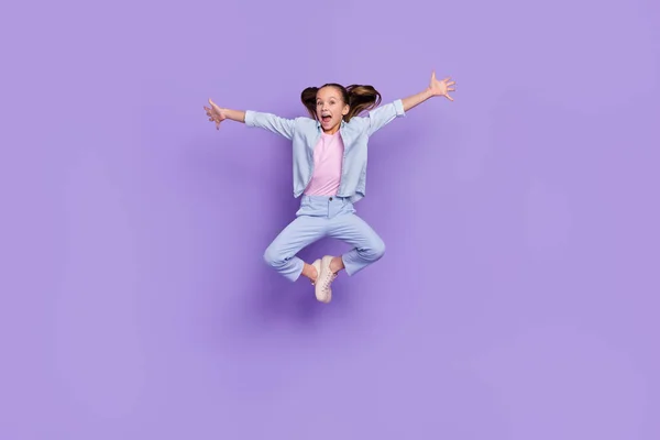 Foto de menina escola muito funky pouco desgaste ganga camisa braços lados saltando alto isolado cor roxa fundo — Fotografia de Stock