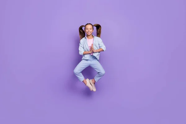 Foto de soñadora linda colegiala pequeña vestida jeans camisa saltando alto practicando yoga aislado violeta color fondo —  Fotos de Stock