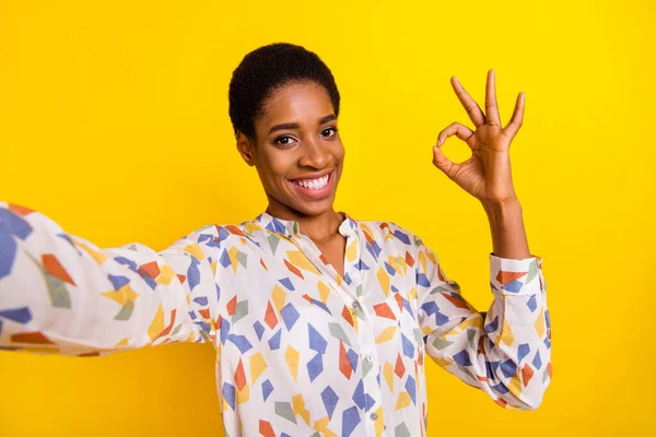 Foto dari seorang narablog yang bersahabat dengan ceria membuat jari tangan selfie menunjukkan okey terisolasi pada latar belakang warna kuning — Stok Foto
