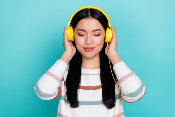 Foto av trevlig tusenårig dam lyssna musik bära hörlurar randig pullover isolerad på turkos färg bakgrund — Stockfoto