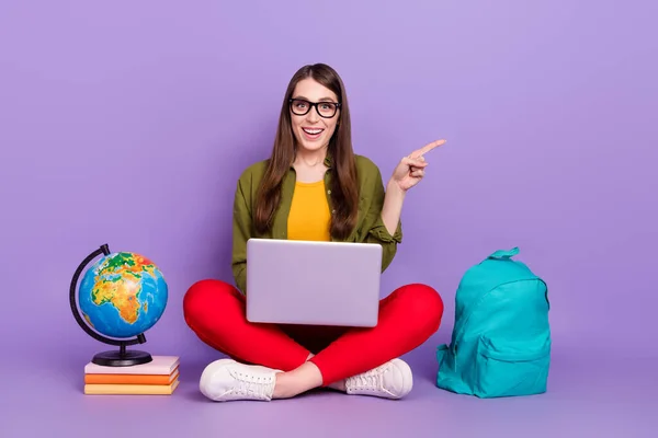 Portré vonzó vidám lány segítségével laptop mutatja másolás tér hirdetés csinál házi feladatot elszigetelt ibolya lila színű háttér — Stock Fotó