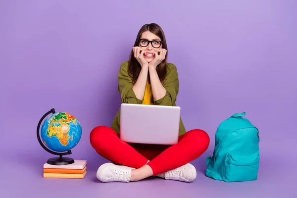 Retrato de chica nerviosa atractiva sentada usando el ordenador portátil haciendo la prueba de comprobación de tareas aislada sobre fondo violeta de color púrpura — Foto de Stock