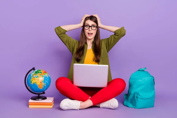 Retrato de chica atónita atractiva sentada usando el proyecto web portátil reacción aislada sobre violeta color púrpura fondo —  Fotos de Stock