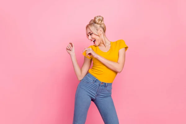 Foto di cute giovane bionda signora danza indossare jeans t-shirt isolato su sfondo di colore rosa — Foto Stock