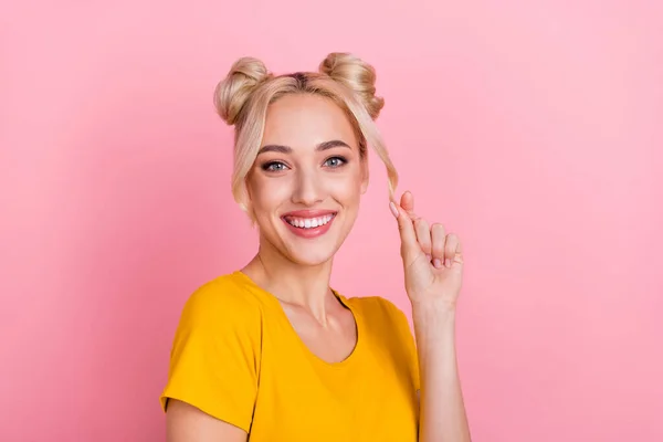 若いブロンドの女性のタッチの髪の写真ピンクの色の背景に隔離された黄色のTシャツを着用 — ストック写真