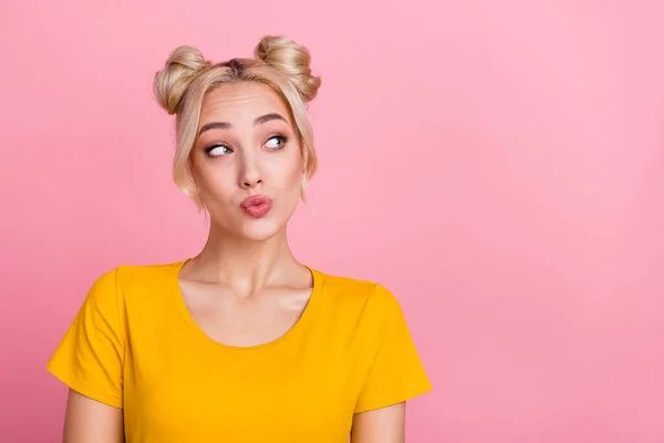 Photo of flirty millennial blond buns hairdo lady look advert wear yellow t-shirt isolated on pink color background — стоковое фото