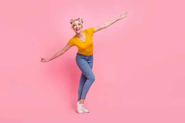 핑크 색 배경에 고립된 티셔츠 청바지 스니커즈를 입고 춤추는 펑키 금발 아가씨의 사진 — 스톡 사진