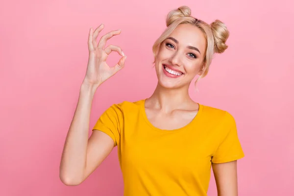 Photo of cute millennial blond lady show okey wear yellow t-shirt isolated on pink color background — стоковое фото