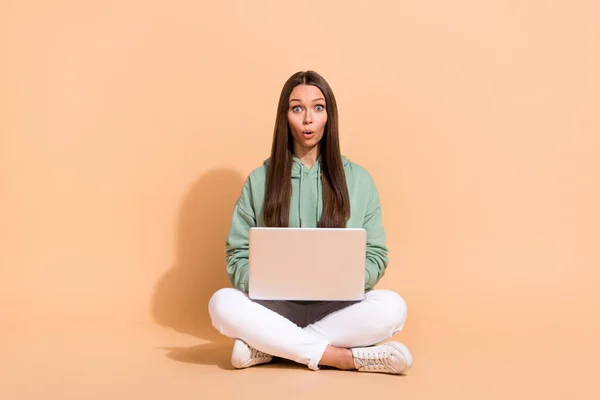 Bej rengi pastel arka planda izole edilmiş laptoplu dudaklar kullanan güzel, afili bir kızın portresi. — Stok fotoğraf