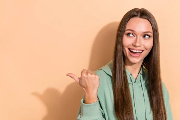 Portret van aantrekkelijke vrolijke meisje demonstreren kopiëren lege ruimte advertentie aanbod look idee geïsoleerd over beige pastel kleur achtergrond — Stockfoto