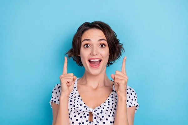 Portret van funky gekke meisje open mond directe vingers omhoog lege ruimte geïsoleerd op blauwe kleur achtergrond — Stockfoto