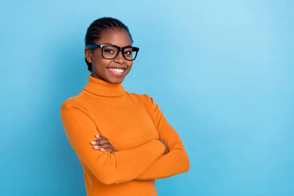 Foto van vrij zelfverzekerde slimme dame gevouwen handen glanzend stralende glimlach dragen specs oranje shirt geïsoleerde blauwe kleur achtergrond — Stockfoto