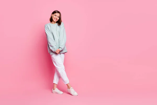 Full length photo of pretty milennial lady stand wear hoodie pants footwear isolated on pink background — 스톡 사진