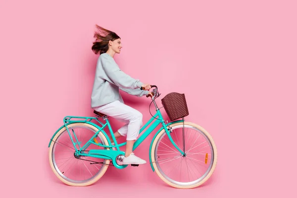 Pleine taille profil côté photo de jeune jolie fille insouciante conduite véhicule à vélo regarder espace vide isolé sur fond de couleur rose — Photo