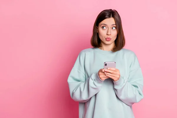 Photo of young pretty girl think look empty space plan use smartphone isolated over pink color background — 스톡 사진