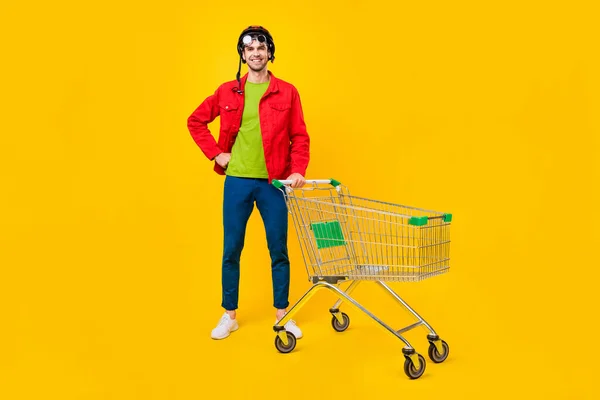 Volledige lichaamsomvang uitzicht van aantrekkelijke vrolijke man kopen goederen slijtage specs geïsoleerd over helder gele kleur achtergrond — Stockfoto