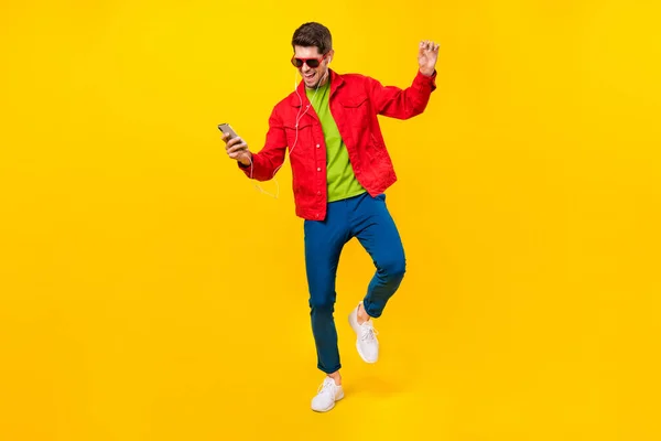Full length body size view of attractive trendy guy listening hit having fun isolated over bright yellow color background — Zdjęcie stockowe