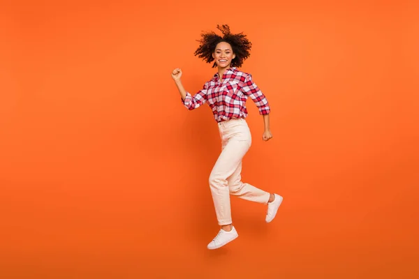 Full längd kroppsstorlek bild av attraktiva glada sportig flicka hoppa kör isolerad på ljusa orange färg bakgrund — Stockfoto