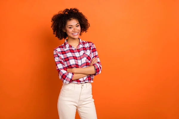 Photo of millennial curly lady crossed palms wear plaid shirt isolated on orange color background — Stock Photo, Image