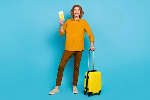 Фотографія повного розміру смішного хорошого настрою чоловік йде на літні канікули в літаку першого класу ізольовано на синьому кольорі — стокове фото
