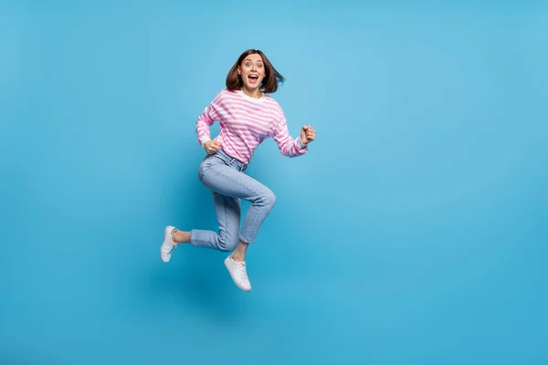 Foto de senhora bonita encantador vestido pulôver rosa saltando alto correndo rápido espaço vazio isolado fundo cor azul — Fotografia de Stock