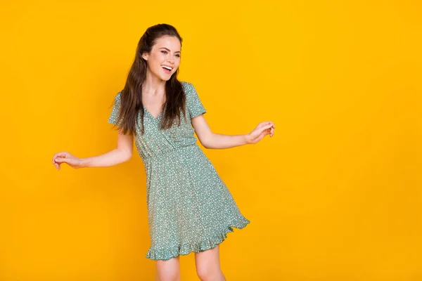 Foto de sonho bonita mulher usar vestido de impressão dançando olhando espaço vazio isolado cor amarela fundo — Fotografia de Stock