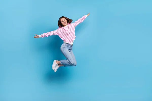 フルサイズの写真の感銘を受けた若い女性ジャンプウェアシャツジーンズスニーカー隔離された青の背景 — ストック写真