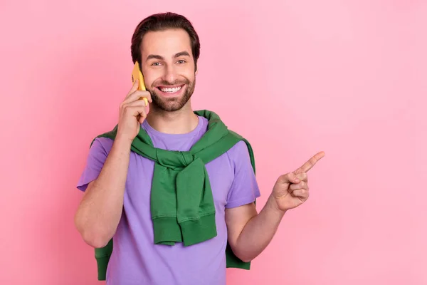 Foto van koele duizendjarige baard man praten telefoon index promo slijtage violet t-shirt groen sweatshirt geïsoleerd op roze kleur achtergrond — Stockfoto