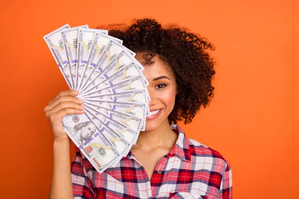 Photo of pretty wavy lady hold money close face wear red shirt isolated on orange background — ストック写真