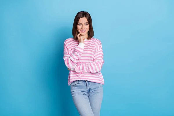 可爱的鲍伯风格的千禧年女士认为穿着粉色衬衫牛仔裤与蓝色背景隔离的照片 — 图库照片