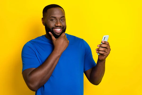Portrait of attractive cheerful guy using device notification post smm app 5g isolated over shine yellow color background — ストック写真