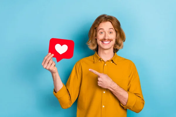 Portrait of attractive trendy cheerful long-haired guy holding demonstrating like card rate isolated over bright blue color background — стоковое фото