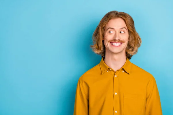 Porträtt av attraktiv glad långhårig kille tittar åt sidan tänkande kopia utrymme lösning isolerad över klarblå färg bakgrund — Stockfoto