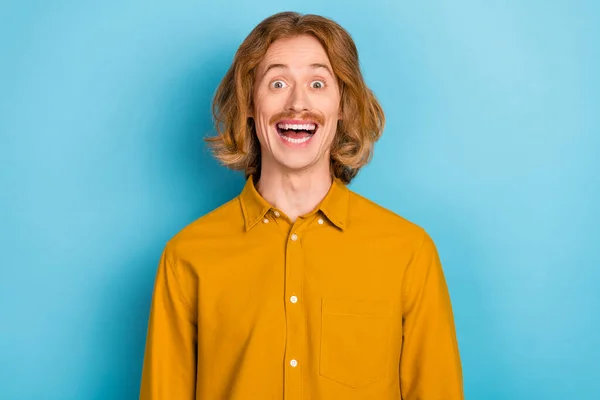 Portré vonzó vidám őrült hosszú hajú srác szórakozás nagy hír elszigetelt felett fényes kék színű háttér — Stock Fotó