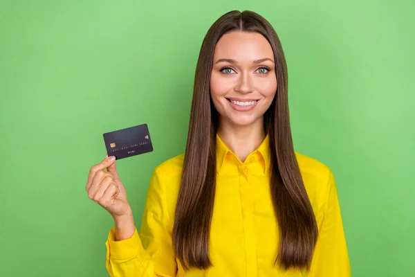Foto av ung vacker flicka hålla kreditkort inkomster förmån inkomst isolerad över grön färg bakgrund — Stockfoto