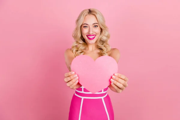 Фото позитивной романтической девушки продемонстрировать сердце фигуры носить модные полосатые платья изолированный розовый цвет фона — стоковое фото